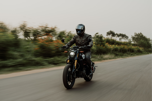 Motociclista na estrada com capacete fechado